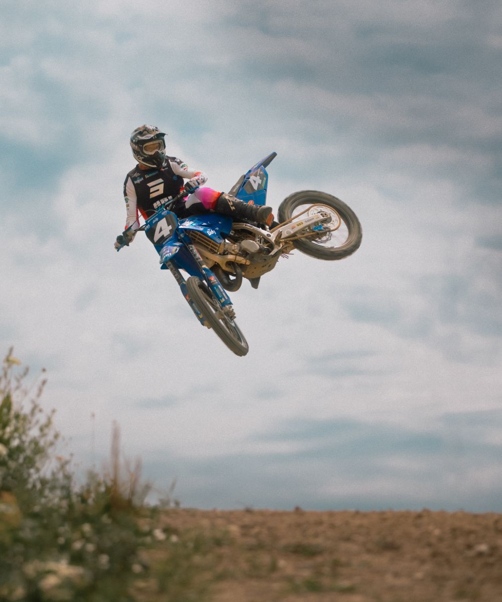 IN&MOTION_MX-46 (1) Pilote de motocross en plein saut sur circuit terre, équipé d’un gilet airbag In&motion, illustrant la sécurité et la performance en moto tout-terrain