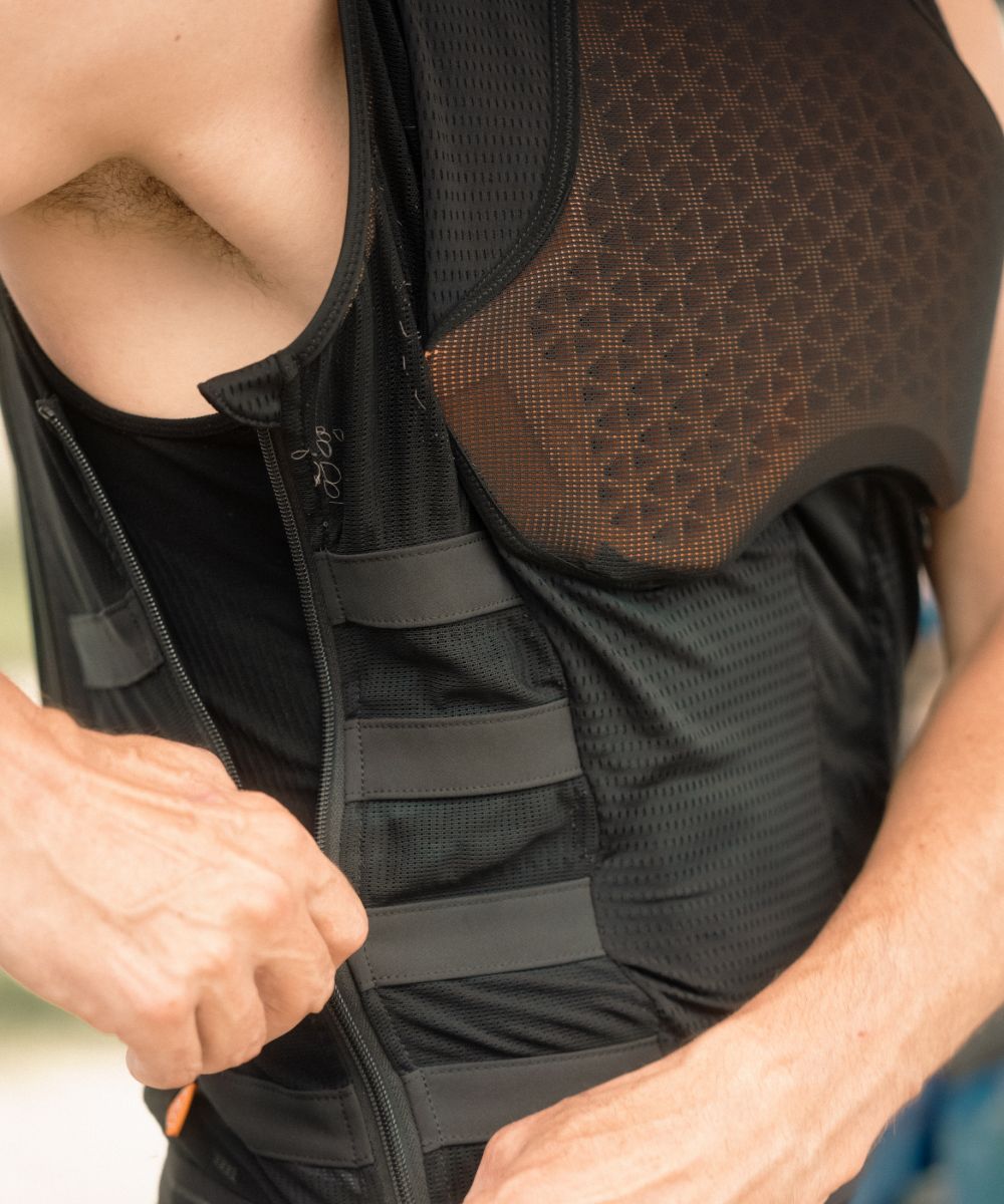 IN&MOTION_MX-54 (1) Gros plan sur un motard fermant un gilet airbag In&motion, protection thoracique ventilée haute performance pour motocross